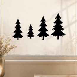 Vier zwarte herbruikbare kerstbomen raamstickers in verschillende formaten van 12 tot 22 cm op een raam.